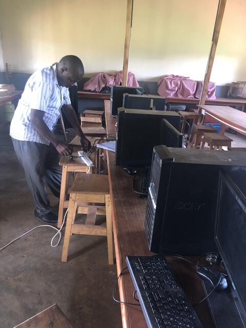 Mr. Katumba making connections in Kalere SS computer lab